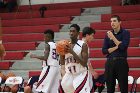 Coach Wilson observing Freshman Paul Phillips on the court. 