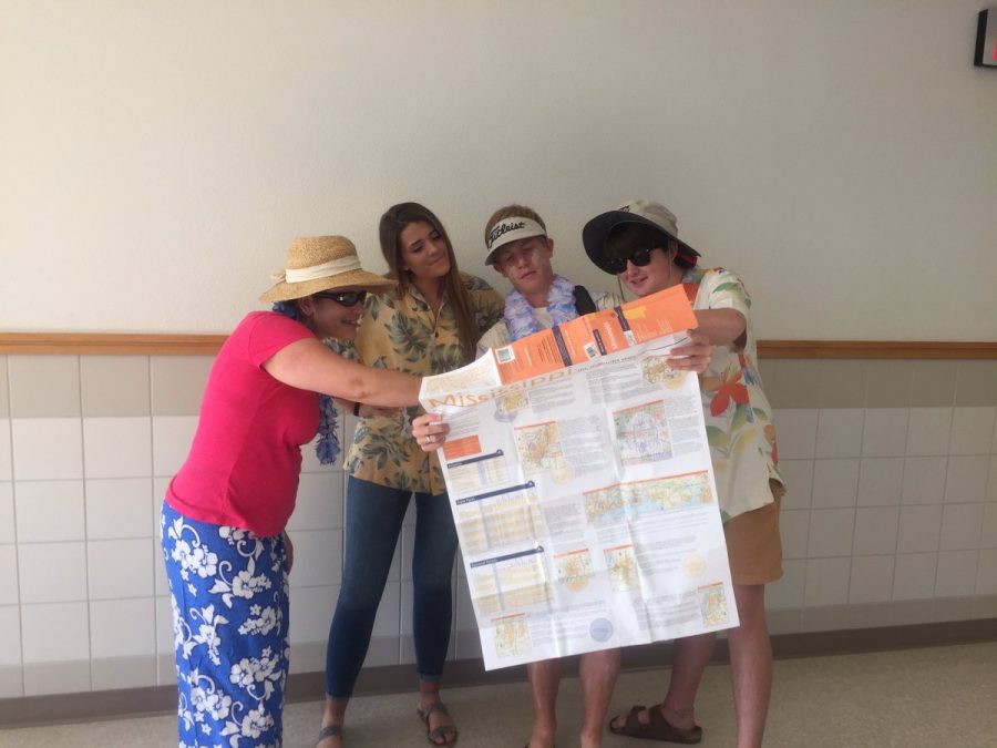 Students and teachers look at a map of their vacation spot