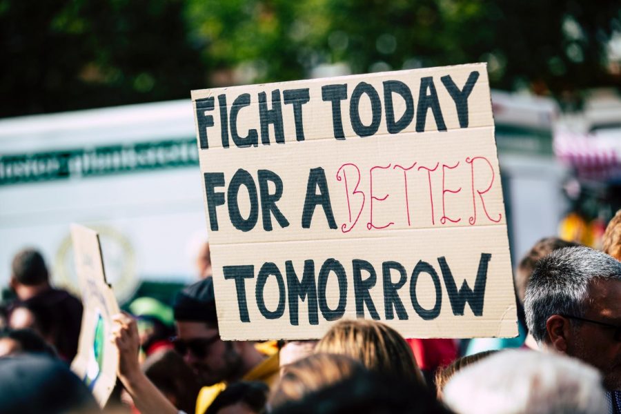 a person holding up a sign that reads 
fight today for a better tomorrow.