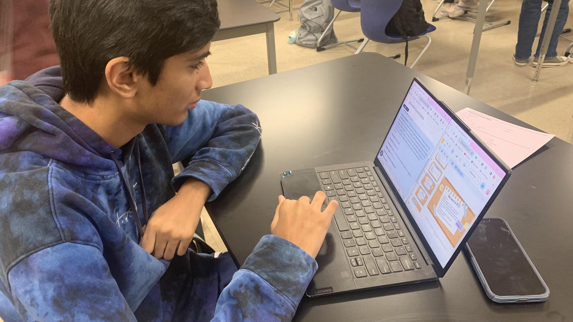 Sritan Bhumireddy looks over the course catalog and the slideshow provided by Centennial. 