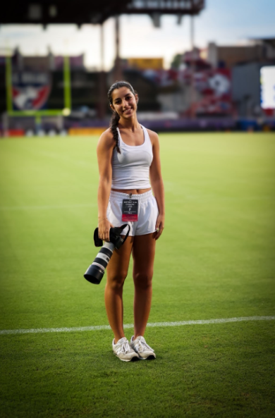 Rotem Marom posing at the first football game, taking pictures of the event.